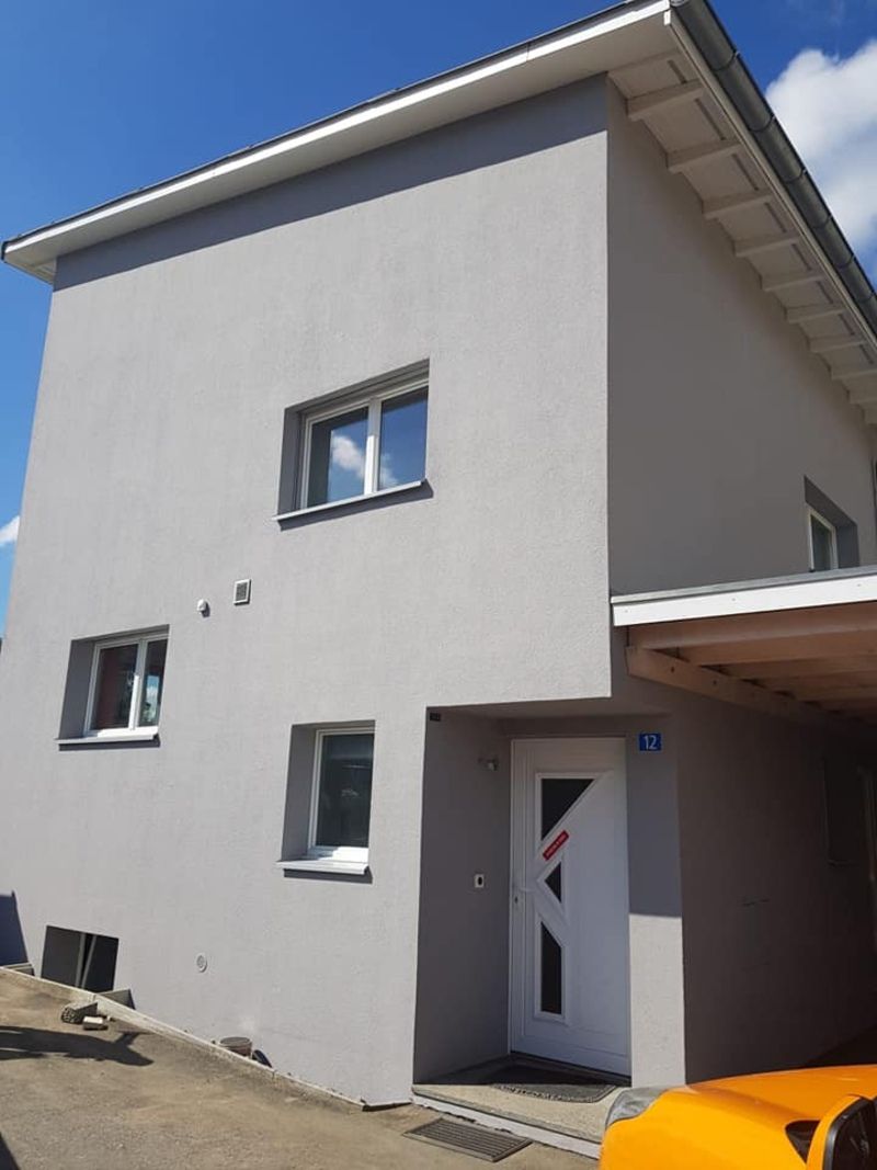 Villa avec façade grise et encadrements blancs